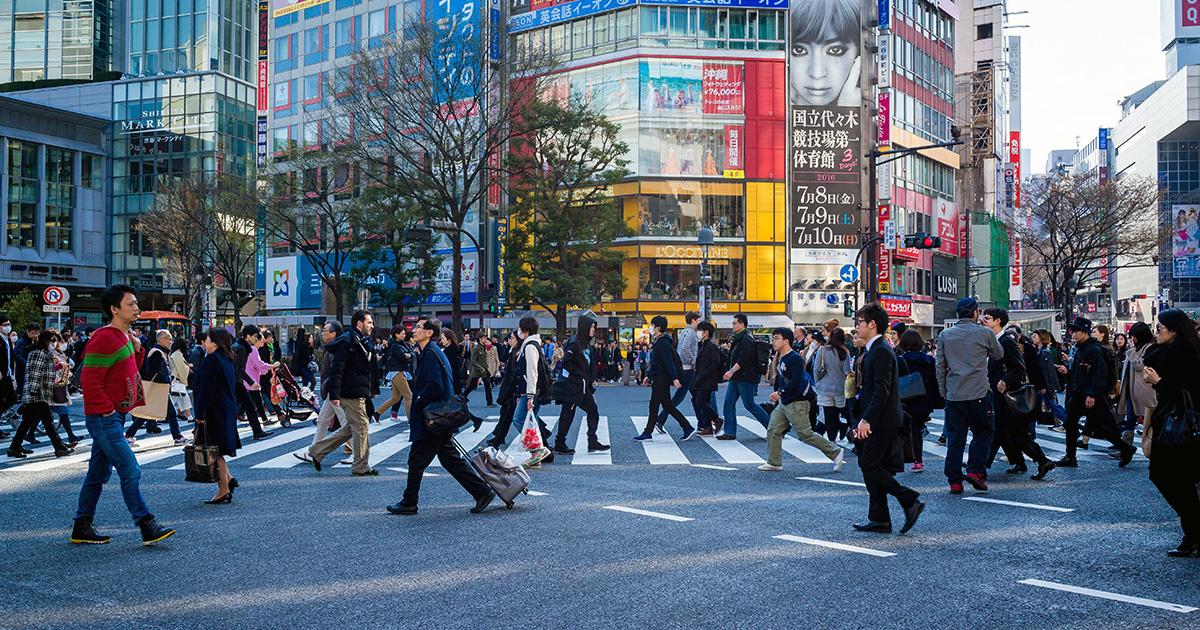 Busy street in Japan with many people crossing the road